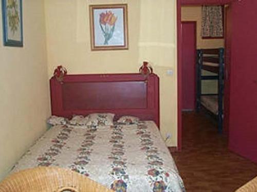 une chambre avec un lit avec une tête de lit rouge dans l'établissement Studio cabine ensoleillé proche plage avec parking privatif - FR-1-328-140, à La Grande Motte