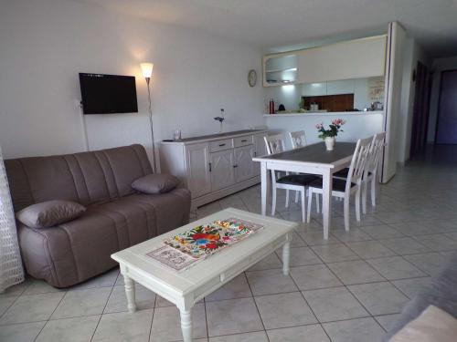 un salon avec un canapé et une table dans l'établissement Appartement 3 pièces avec loggia, jardin, accès direct plage, garage - La Grande-Motte - FR-1-328-111, à La Grande Motte
