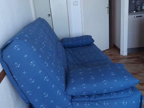 un canapé bleu avec des draps bleus dessus dans l'établissement Studio Cabine avec Piscine sur la Plage, Parking, 21m², 4 Pers, La Grande Motte - FR-1-328-157, à La Grande Motte