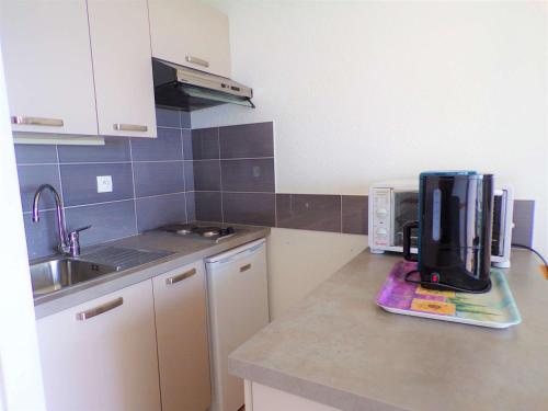 une cuisine avec une cafetière sur un comptoir dans l'établissement Studio Cabine avec Piscine sur la Plage, Parking, 21m², 4 Pers, La Grande Motte - FR-1-328-157, à La Grande Motte