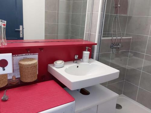 La salle de bains est pourvue d'un lavabo blanc et d'un comptoir rouge. dans l'établissement Appartement 2 Pièces Cabine, Proche Plage, 5 Pers., Parking, Terrasse - FR-1-328-201, à La Grande Motte