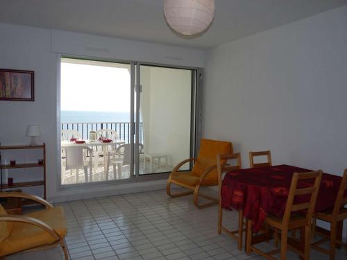 un salon avec une table et des chaises et un balcon dans l'établissement Studio Cabine Spacieux avec Parking et Vue - FR-1-328-214, à La Grande Motte