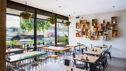 a restaurant with tables and chairs and a large window at VAQUAY El Karnak In Brunswick West in Melbourne