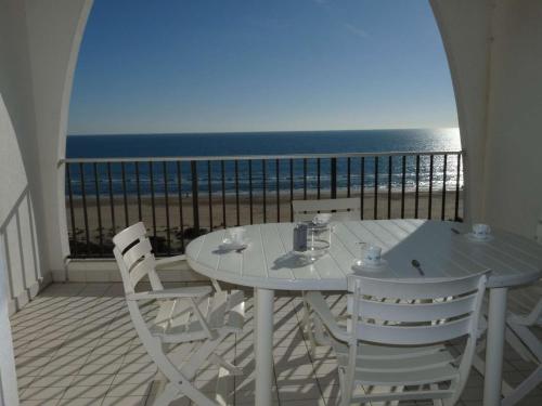 une table blanche et des chaises sur un balcon avec l'océan dans l'établissement Appartement 2P en bord de mer avec parking, La Grande-Motte - FR-1-328-202, à La Grande Motte