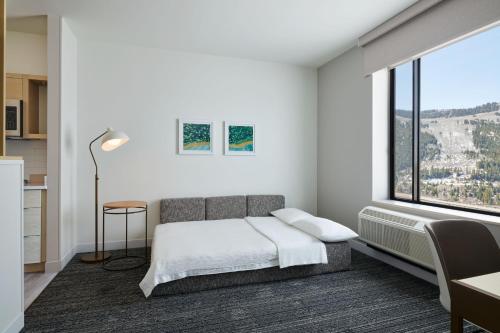 sypialnia z łóżkiem i dużym oknem w obiekcie TownePlace Suites by Marriott Avon Vail Valley w mieście Avon