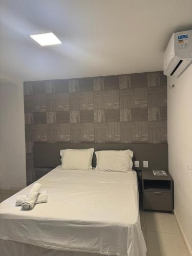 a bedroom with a large bed with white sheets at Golf Ville Resort in Aquiraz