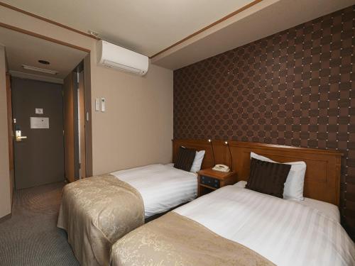 a hotel room with two beds in a room at Hotel Arthur KITAHAMA BASE in Beppu