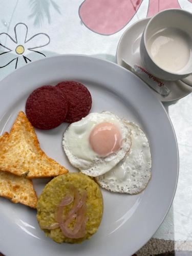 a plate of food with eggs and toast and a cup of coffee at Hotel Frano Romana Center in La Romana