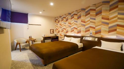 柳川市にあるホテルニューガイア柳川のベッド2台とデスクが備わるホテルルームです。