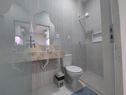 W łazience znajduje się toaleta, umywalka i lustro. w obiekcie Pousada Luz do Sol w mieście Piranhas