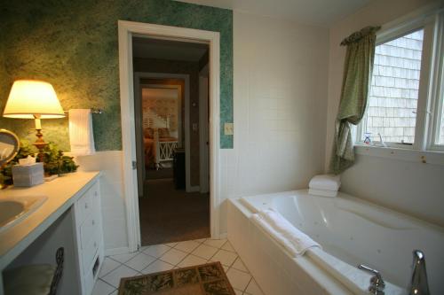 a bathroom with a tub and a sink at Lamb and Lion Inn in Barnstable