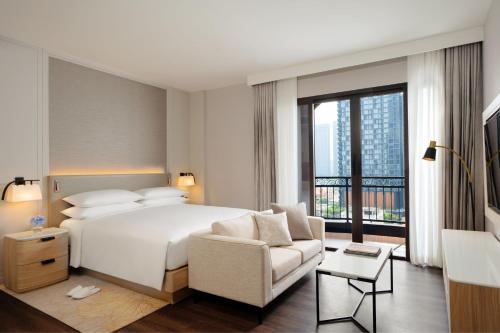 une chambre d'hôtel avec un lit, un canapé et une fenêtre dans l'établissement Marriott Executive Apartments Bangkok, Sukhumvit 101, à Bangkok