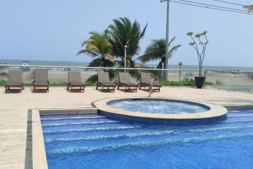 una piscina con sedie e l'oceano sullo sfondo di Apartamento en Cartagena de Indias, Edificio Morros 3 a Cartagena de Indias