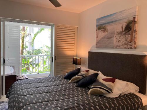 een slaapkamer met een bed en uitzicht op het strand bij Beach Club Private Apartments Palm Cove in Palm Cove