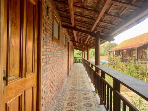 a corridor of a building with a wooden door at Nhà Gỗ An Nhiên in Xóm Chum Găng