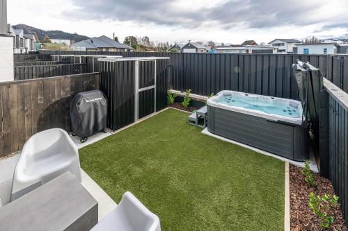 a small backyard with a hot tub and grass at Riverside Lodge - Luxury Two Bedroom With Hot Tub in Albert Town