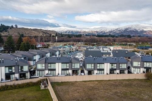 a row of houses with mountains in the background at Riverside Lodge - Luxury Two Bedroom With Hot Tub in Albert Town