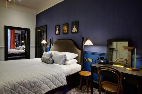 a bedroom with a bed and a desk with a mirror at Abbey Hotel Bath, a Tribute Portfolio Hotel in Bath