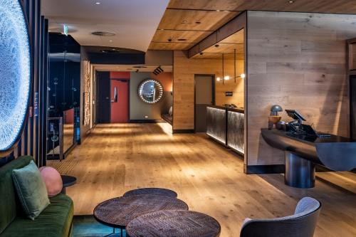 a lobby with wooden floors and a sink and tables at QT Auckland in Auckland