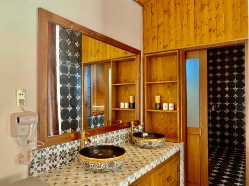 a bathroom with two sinks on a counter at Nhà Gỗ An Nhiên in Xóm Chum Găng