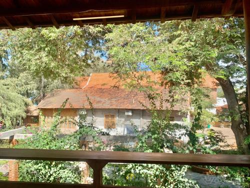 a house with a red roof in front of a window at Nhà Gỗ An Nhiên in Xóm Chum Găng