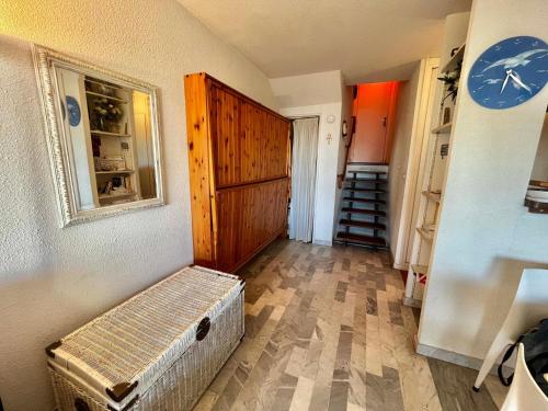 un couloir avec une chambre avec une horloge sur le mur dans l'établissement Studio avec parking, climatisation et terrasse à 500m des plages - FR-1-716-62, à La Grande Motte