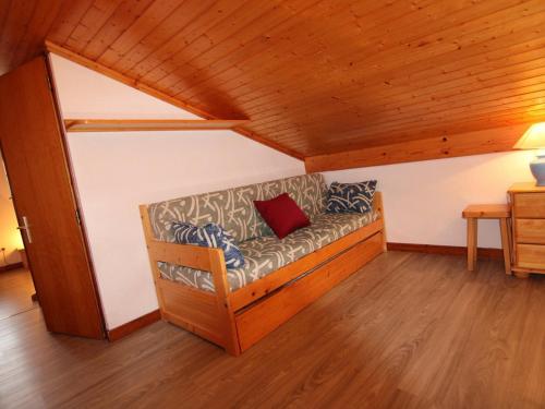 - un canapé avec un oreiller rouge dans l'établissement Appartement cosy aux Saisies, 3 pièces pour 6 personnes - FR-1-594-327, à Hauteluce