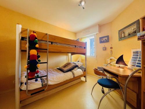 - une chambre avec des lits superposés et un bureau dans l'établissement Appartement T3 70m² à Quiberon avec parking et WiFi, proche plage - FR-1-478-293, à Quiberon
