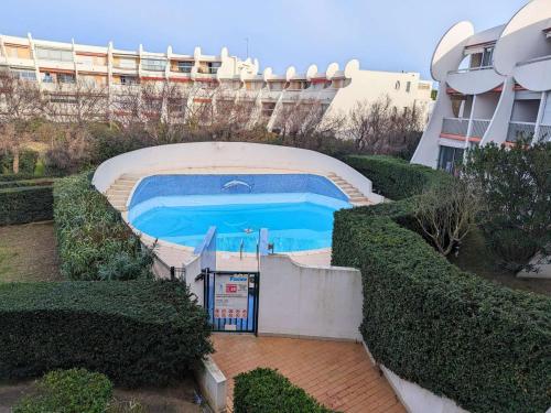 une piscine devant un immeuble dans l'établissement Studio cabine rénové avec piscine, climatisation - La Grande-Motte - FR-1-250-271, à La Grande Motte