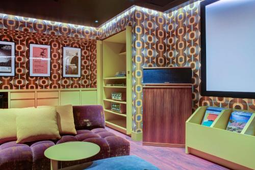 a living room with a couch and a flat screen tv at Moxy Banff in Banff
