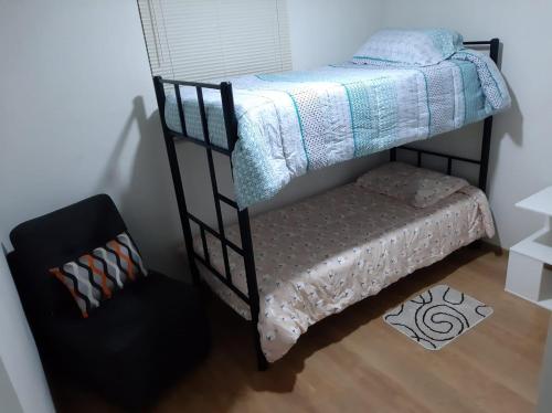 a bedroom with a bunk bed and a chair at Piso 21 - Habitaciones en departamento - compartido in Lima