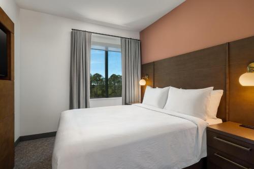 um quarto de hotel com uma cama grande e uma janela em Residence Inn Panama City Beach Pier Park em Panama City Beach