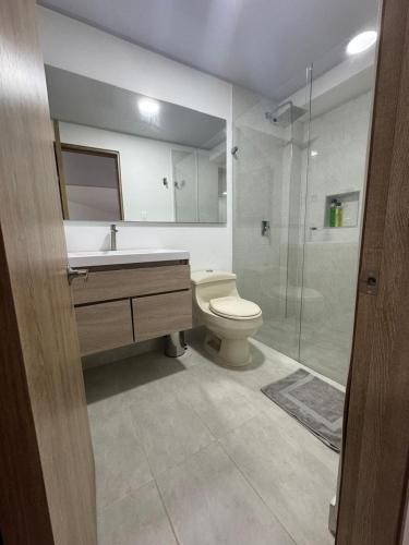 y baño con aseo, lavabo y ducha. en Apartamento tipo Loft nuevo, en Bogotá