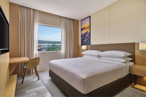 a bedroom with a bed and a desk and a window at Fairfield by Marriott Bintulu Paragon in Bintulu