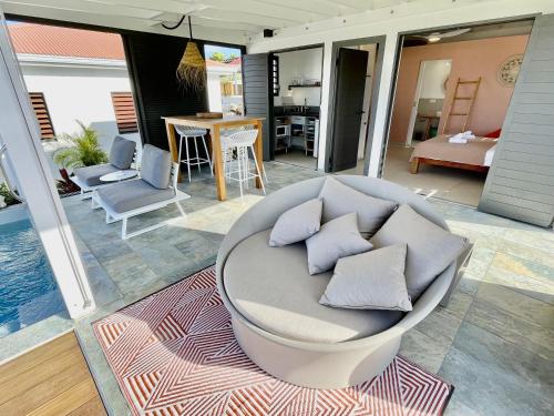 einem runden Stuhl mit Kissen auf einem Teppich auf einer Terrasse in der Unterkunft Galanterie in Grand-Bourg