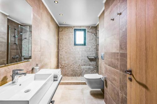une salle de bain avec un lavabo et des toilettes dans l'établissement Lambis Athina, à Lindos