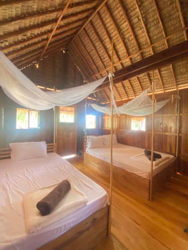 duas camas num quarto com telhado em Lily's Beach Bungalows em Koh Rong Island