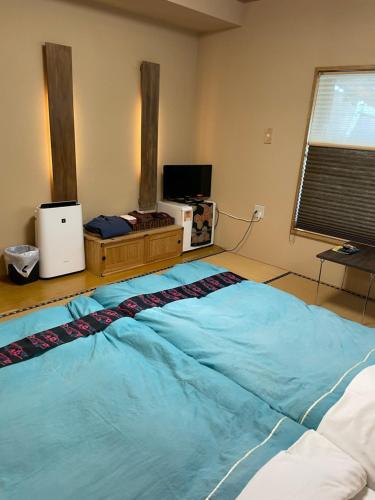 a large blue bed in a room with a window at KAZEMACHIOYADO RAMUYA 〜風待ち御宿　来夢や〜 in Shimoda