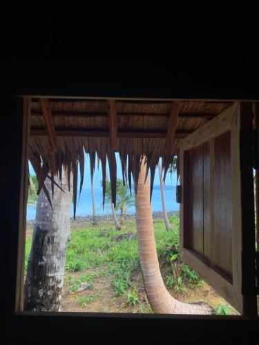 a view of a tree from a window of a house at Lily's Beach Bungalows in Koh Rong Island