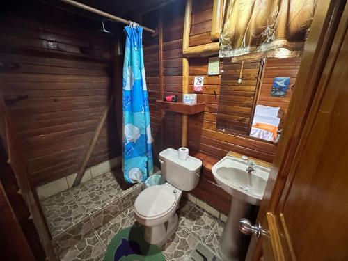 a small bathroom with a toilet and a sink at El Pajas in Puerto Velasco Ibarra