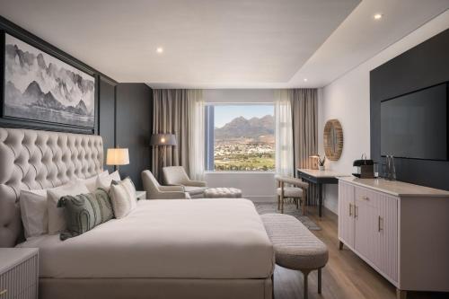 a hotel room with a large bed and a desk at Protea Hotel by Marriott Stellenbosch & Conference Centre in Stellenbosch