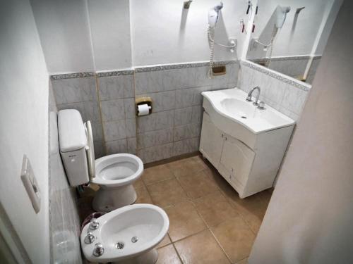a small bathroom with a toilet and a sink at Hotel Cristal in Viedma