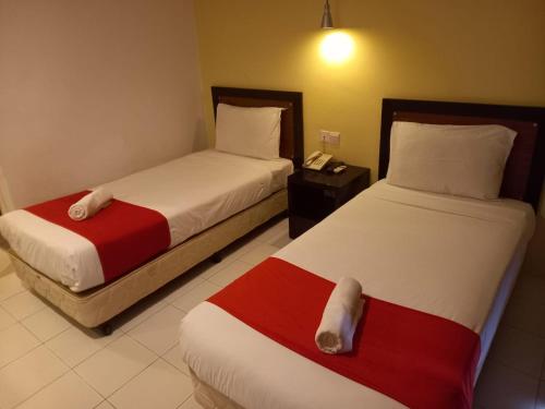 Syajie Koptown Hotel في سيغامات: غرفه فندقيه سريرين وتلفون