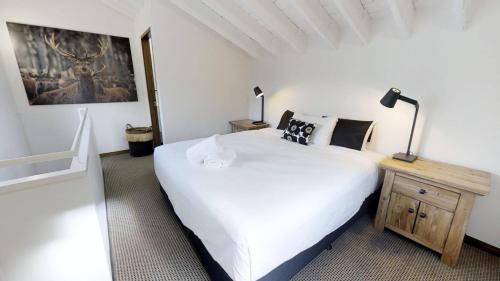 a bedroom with a large white bed and two lamps at Studio Loft 9 The Stables Perisher in Perisher Valley