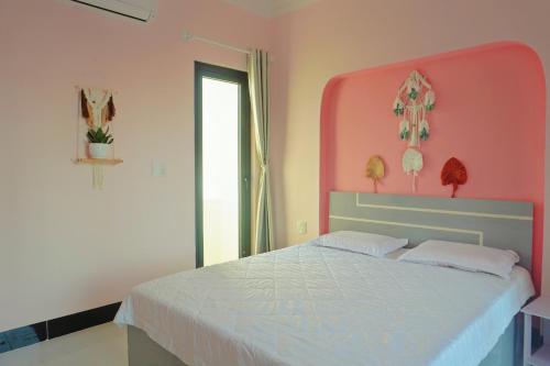 a bedroom with a large bed with a pink headboard at Pink Sea Villa in Cu Lao Thu