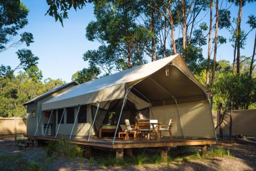 a tent with a table and chairs in it at Tanja Lagoon Camp in Tanja