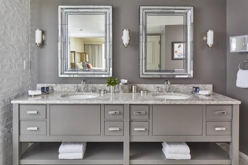 a bathroom with two sinks and two mirrors at Grand Hotel Golf Resort & Spa, Autograph Collection in Point Clear