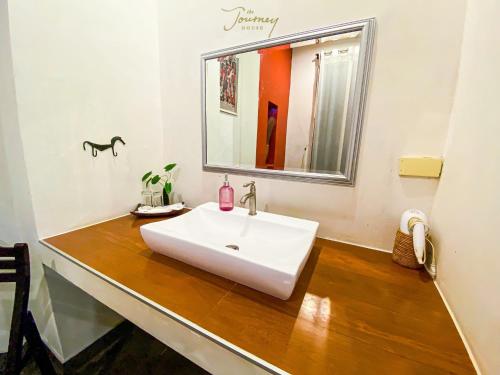 a bathroom with a white sink and a mirror at The Journey House Lifestyle Boutique Hotel in Kanchanaburi