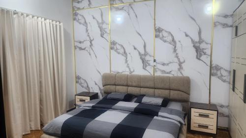 1 dormitorio con cama y pared de mármol en الجبيل, en Al Jubail