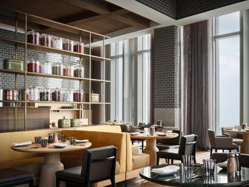 a restaurant with tables and chairs and windows at Rosewood Guangzhou, enjoy free shuttle bus service between the hotel and the Canton Fair Complex during the Canton Fair in Guangzhou